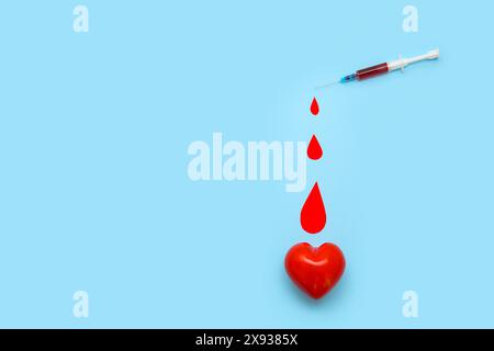 Composition avec coeur, gouttes de papier et seringue sur fond bleu Banque D'Images