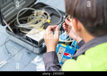 Le technicien prend en charge la qualité de l'air du tube d'échantillonnage dans la bobine de la pompe de la machine pour la mesure. Banque D'Images