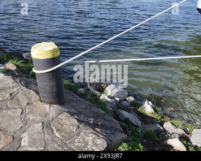 Borne d'amarrage avec une seule ligne attachée au bord de l'eau Banque D'Images