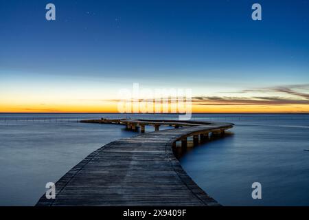 Pont touristique panoramique sur la rive de la mer sous le coucher du soleil, illuminé de nuages roses. Zones humides de Gaomei, Taichung City, Taïwan Banque D'Images