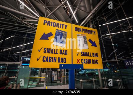 Priorité non prioritaire Schild, Flughafen, Köln-Bonn, Deutschland, Ryanair, Gepäckbestimmungen, Priorität, Nicht-Priorität, kleine Tasche, Kabinentasche, Gepäckregeln, embarquement, terminal, Passagiere, Flugreise, Wartebereich, gelbes Schild, Hinweise, Boarding-Prozess, Flughafenbetrieb, Reisende, Fluggesellschaft, Gepäckvorschriften, Flughafeninformation. *** Panneau prioritaire non prioritaire, aéroport, Cologne Bonn, Allemagne, Ryanair, réglementation des bagages, priorité, non priorité, petit sac, sac cabine, règles relatives aux bagages, embarquement, terminal, passagers, voyage aérien, salle d'attente, panneau jaune, instructions, boardi Banque D'Images