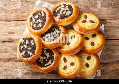 Petits pains à la levure sucrés kolache tchèque fait avec du fromage cottage ou des graines de pavot en gros plan sur la table en bois. Vue horizontale de dessus Banque D'Images