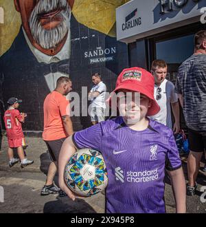 LIVERPOOL, ANGLETERRE - 19 MAI : jeune supporter de Liverpool tenant un ballon de football à Anfield pendant le match de premier League anglaise. Banque D'Images