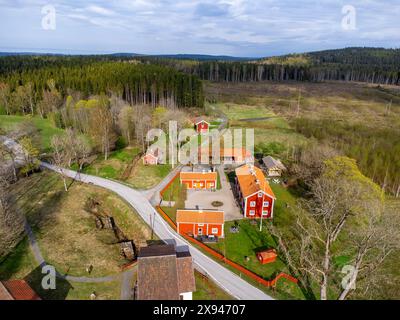 Vue aérienne d'un village de campagne avec des bâtiments oranges entourés de verdure luxuriante, capturant le charme rural. Banque D'Images