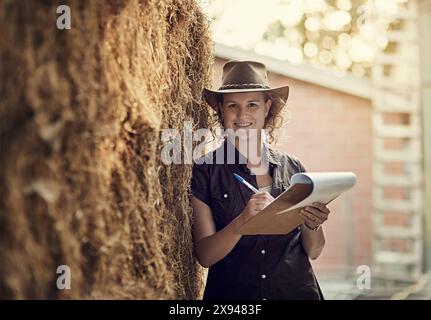 Femmes, presse-papiers et portrait à la ferme pour le calendrier d'inspection, la planification et l'examen. Agriculteur féminin, travaillant et notes ou s'appuyant sur l'arbre pour Banque D'Images