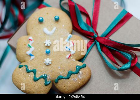 De petits hommes en pain d'épice décorés de Noël sont allongés sur la table près des boîtes en carton, prêts à être emballés. Banque D'Images