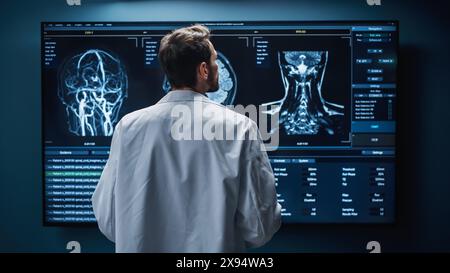 Laboratoire de recherche de l'hôpital médical : neuroscientifique masculin blanc regardant l'écran de télévision, analysant des images IRM de balayage du cerveau, trouver un traitement pour le patient. Neurologue de soins de santé soignant les gens. Zoom de la vue arrière Banque D'Images