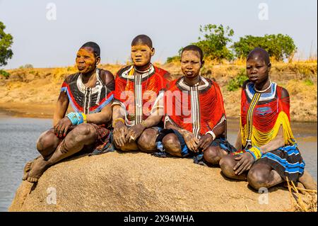 Femmes Mundari en robes traditionnelles, avec des cicatrices faciales et des cendres sur les visages, posant sur un rocher, tribu Mundari, Soudan du Sud, Afrique Banque D'Images