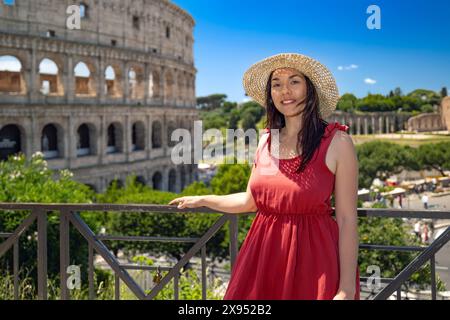 Brune fille avec chapeau de paille admire la majesté du Colisée et en arrière-plan les ruines antiques du Forum romain à Rome, en Italie. Banque D'Images