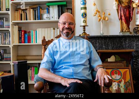 Portraitiste catholique Tilburg, pays-Bas. Salon Portrait d'un prêtre catholique de 56 ans assis dans son fauteuil de lecture, se préparant mentalement et spirituellement à sa nouvelle commande qui lui a été donnée par son évêque. MRYES Tilburg Parochie Binnenstad Nootd-Brabant Nederland Copyright : xGuidoxKoppesxPhotox Banque D'Images