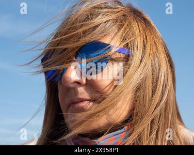 Vue rapprochée d'une femme avec des lunettes de soleil qui regardent loin tout en se relaxant à l'extérieur. Banque D'Images