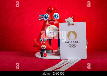 ZHONGSHAN Chine-22 mai 2024 : 2024 Paris Jeux Olympiques et Jeux Paralympiques mascottes les Phryges avec carte IC sur fond rouge à la composition horizontale Banque D'Images