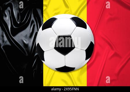 FOTOMONTAGE, Schwarz-Weißer Lederfußball mit Fahne von Belgien Banque D'Images