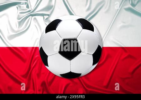 FOTOMONTAGE, Schwarz-Weißer Lederfußball mit Fahne von Polen Banque D'Images