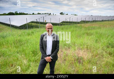 Zeithain, Allemagne. 29 mai 2024. Wolfram Günther (Bündnis90/Die Grünen), ministre de l'environnement de Saxe, se tient devant les modules solaires de l'Enerparc Solarpark Zeithain lors de l'inauguration officielle. D’une superficie de plus de 95 hectares, le parc solaire d’un ancien site militaire est le plus grand du district de Meißen et alimente environ 25 000 foyers en électricité verte. (Photo prise avec un drone). Crédit : Robert Michael/dpa/Alamy Live News Banque D'Images