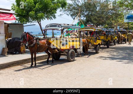 Des charrettes à chevaux traditionnelles (Cidomo) attendent à côté du port sur la rue principale de l'île Gili Trawangan à In Banque D'Images