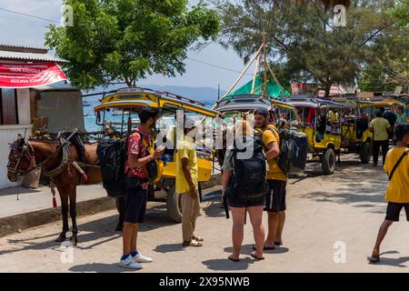 Des charrettes à chevaux traditionnelles (Cidomo) attendent à côté du port sur la rue principale de l'île Gili Trawangan à In Banque D'Images