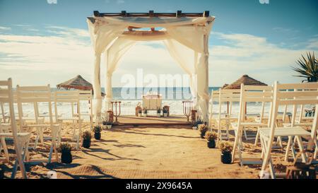 Espace de mariage vide décoré en plein air avec chaises pour cérémonie officielle sur une plage près de la mer ou de l'océan. Tout préparé pour de belles célébrations de mariage romantique. Les clients arrivent bientôt. Banque D'Images