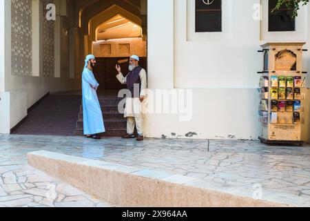 Dubaï, Émirats arabes Unis - 6 janvier 2024 : au cœur de la vieille ville de Dubaï, deux résidents partagent un moment de discussion par une journée ensoleillée. Banque D'Images