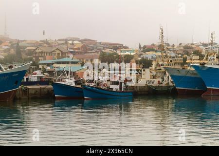 Bateaux de pêche dans un paysage brumeux dans un petit port en Namibie Banque D'Images