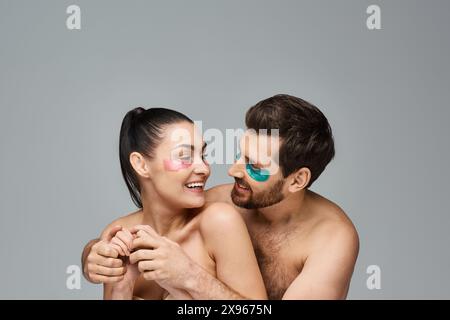 Un couple séduisant, avec des cache-yeux, pose ensemble dans un spectacle enchanteur. Banque D'Images