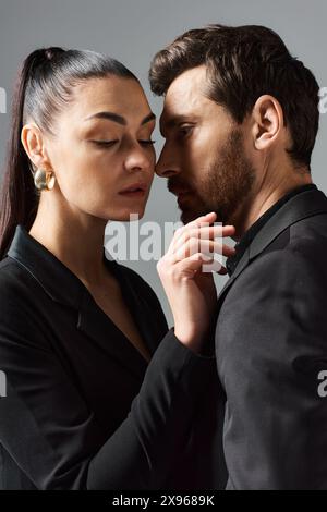 Un homme et une femme en tenue élégante debout côte à côte dans une pose aimante. Banque D'Images