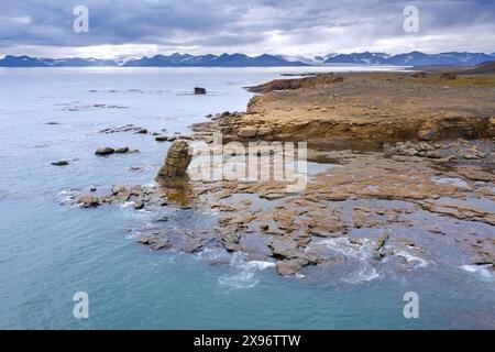 Vue aérienne sur les formations rocheuses le long de la côte rocheuse de Boltodden en été, Kvalvågen, Svalbard / Spitzberg, Norvège Banque D'Images