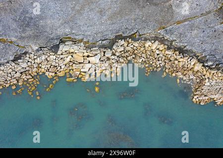 Vue aérienne sur l'érosion côtière montrant le rivage en ruine le long de la côte rocheuse de Boltodden en été, Kvalvågen, Svalbard / Spitzberg, Norvège Banque D'Images