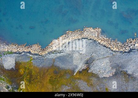 Vue aérienne sur l'érosion côtière montrant le rivage en ruine le long de la côte rocheuse de Boltodden en été, Kvalvågen, Svalbard / Spitzberg, Norvège Banque D'Images