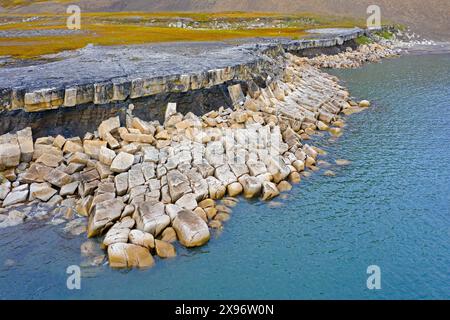 Vue aérienne sur l'érosion côtière montrant le rivage en ruine le long de la côte rocheuse de Boltodden en été, Kvalvågen, Svalbard / Spitzberg, Norvège Banque D'Images