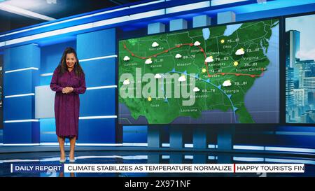 Programme de prévisions météo TV : L'animateur de télévision professionnel examinant le rapport météo dans Newsroom Studio, utilise le grand écran avec des visuels. La célèbre présentatrice parle. Concept de canal de câble maquette. Banque D'Images