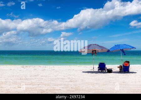 Plage ensoleillée avec parasol coloré et chaises de plage dans la plage tropicale Banque D'Images