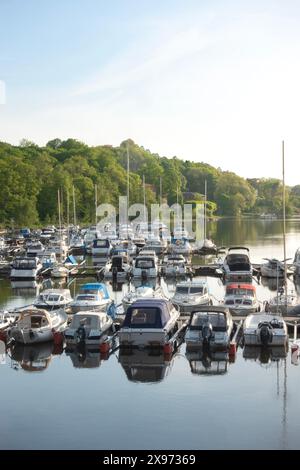 Marina de petits bateaux dans l'eau calme avec forêt verte en arrière-plan dans l'après-midi soleil d'été Banque D'Images