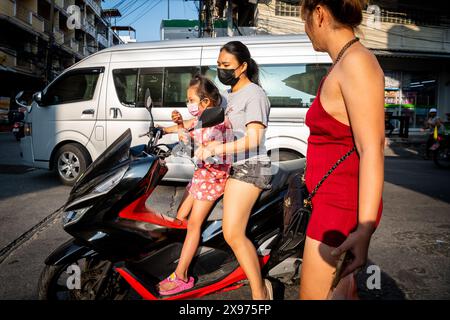 Une mère thaïlandaise vient chercher sa fille à l'école et rentre à la maison sur un scooter à Pattaya Thaïlande. Voyage le long de soi Buakhao centre Pattaya. Banque D'Images