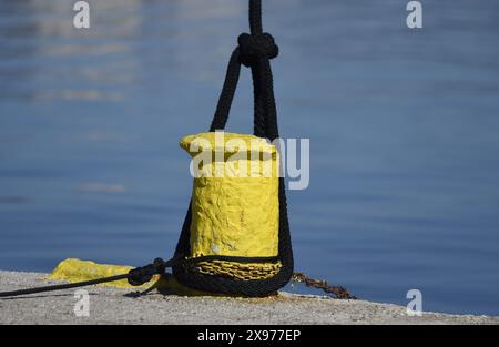 Corde d'amarrage attachée sur une borne jaune au port de Nauplie dans le Péloponnèse, en Grèce. Banque D'Images