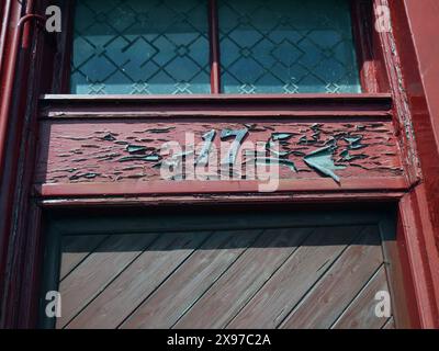 MILLPORT, ÎLE DE CUMBRAE, NORTH AYRSHIRE, ÉCOSSE, 05-02-24. Peinture délavée et altérée et porte numéro 17. Banque D'Images