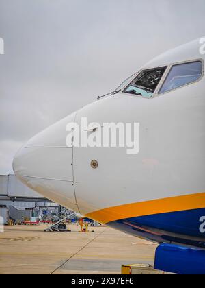 Vue latérale de l'avant de l'aéronef de passagers et du poste de pilotage debout dans un stationnement sur la piste de l'aéroport. Banque D'Images