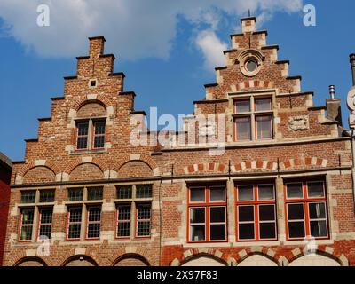 Architecture en brique avec de magnifiques pignons à gradins et fenêtres silhouettées sur un ciel bleu, façades médiévales avec églises et bâtiments historiques Banque D'Images