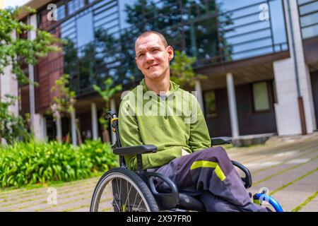 Portrait rapproché d'un homme fier atteint de paralysie cérébrale dans le campus universitaire regardant vers le haut Banque D'Images