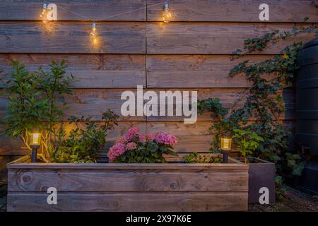 Petite lanterne solaire dans la jardinière et sur la clôture. Lampe solaire dans le jardin Banque D'Images