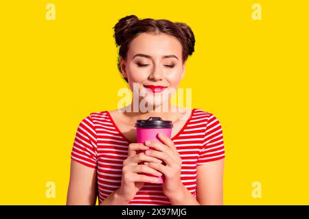 Portrait en gros plan d'elle elle belle jolie jolie jolie belle gentille gentille douce tendre joyeuse fille portant un t-shirt rayé sentant le chocolat chaud isolé sur Banque D'Images