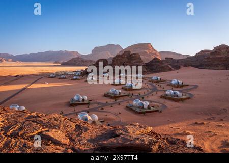 Vue panoramique du camp de tentes à bulles dans le désert de Wadi Rum en Jordanie au lever du soleil contre le ciel bleu Banque D'Images