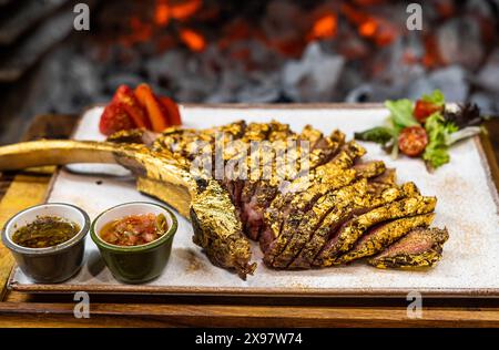 Tomahawk de bœuf de qualité supérieure enrobé d'or comestible Banque D'Images