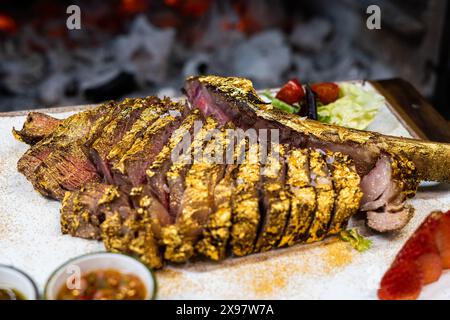 Tomahawk de bœuf de qualité supérieure enrobé d'or comestible Banque D'Images