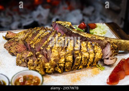 Tomahawk de bœuf de qualité supérieure enrobé d'or comestible Banque D'Images