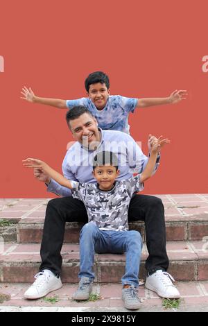Père célibataire divorcé joue avec ses deux enfants latino à la peau foncée et passe du temps de qualité pour célébrer la fête des pères Banque D'Images