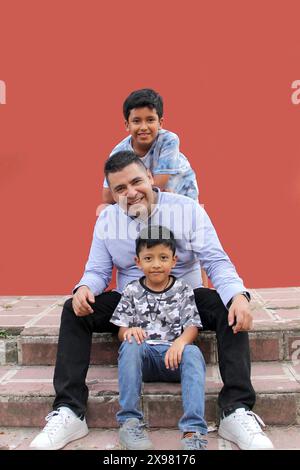 Père célibataire divorcé joue avec ses deux enfants latino à la peau foncée et passe du temps de qualité pour célébrer la fête des pères Banque D'Images