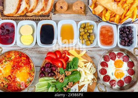 Cuisine turque traditionnelle délicieuse et moderne. Petit-déjeuner turc simple avec des plats d'oeufs de cuivre-poêle, des pâtisseries telles que börek et bagels, confitures, olives, ch Banque D'Images