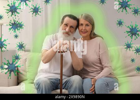 Couple senior à la maison. Immunité forte - résistance contre les infections. Illustration des virus et aperçu Banque D'Images