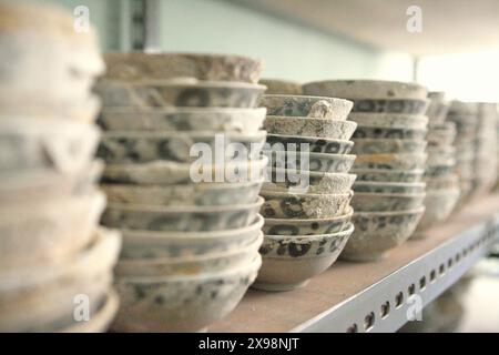 Anciens bols en céramique chinois connus sous le nom de «Yue ware» sans eau du 9ème-10ème siècle Cirebon naufrage trouvé en 2003 dans la mer de Java au nord de Cirebon, Java occidental ; photographié dans la salle de stockage de la Direction de l'archéologie subaquatique, ministère indonésien de la culture et du Tourisme à Jakarta, Indonésie. Depuis les années 1960, l’Asie du Sud-est a connu une forte augmentation de la récupération commerciale et illicite du patrimoine culturel subaquatique, selon une équipe de scientifiques dirigée par Natali Pearson (maître de conférences, Sydney Southeast Asia Centre, Université de Sydney) dans leur article publié sur The conversation. Banque D'Images